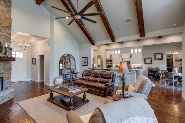 living room featuring a stone fireplace, a notable chandelier, visible vents, and high vaulted ceiling