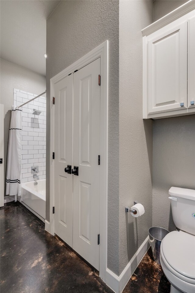 full bath featuring toilet, shower / bath combo, baseboards, concrete flooring, and a textured wall