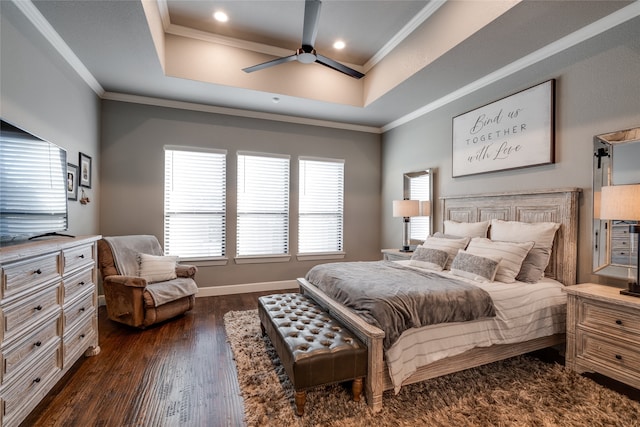 bedroom with dark wood-style floors, a raised ceiling, and ornamental molding