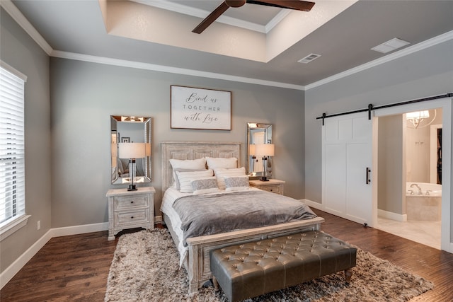 bedroom with a barn door, dark wood-style floors, ornamental molding, and visible vents