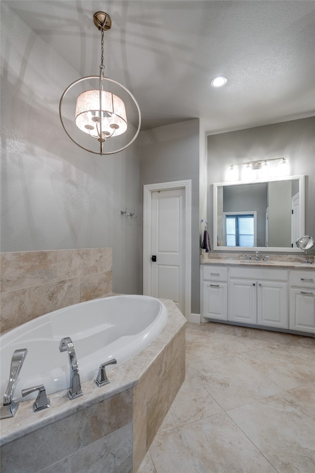 bathroom with a bath, a textured ceiling, and vanity