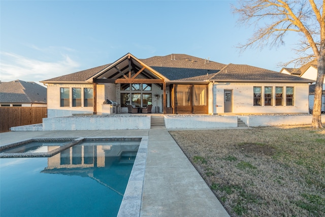 back of house featuring an in ground hot tub, fence, a patio area, and a fenced in pool