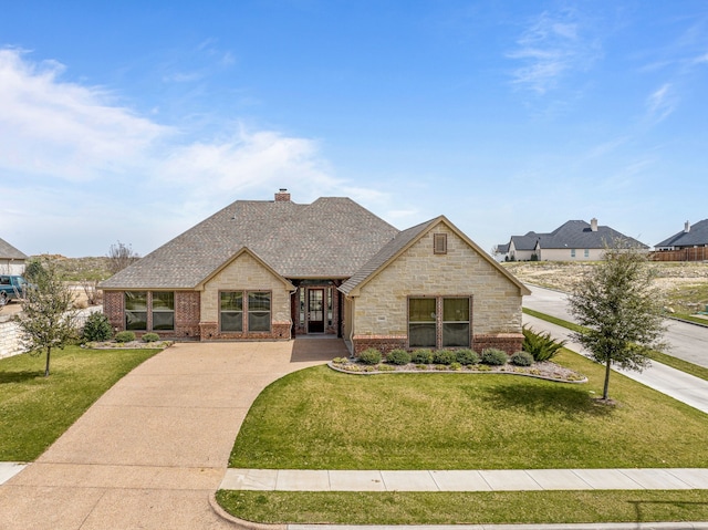 french country home featuring a front yard, brick siding, roof with shingles, and a chimney