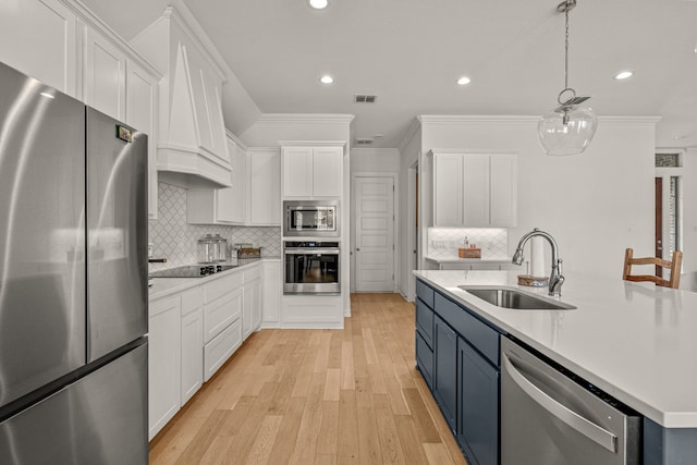 kitchen featuring white cabinetry, light countertops, appliances with stainless steel finishes, and a sink