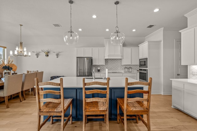 kitchen with decorative backsplash, appliances with stainless steel finishes, light countertops, and light wood-style floors