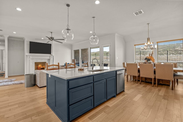 kitchen with visible vents, a sink, light wood-type flooring, light countertops, and stainless steel dishwasher