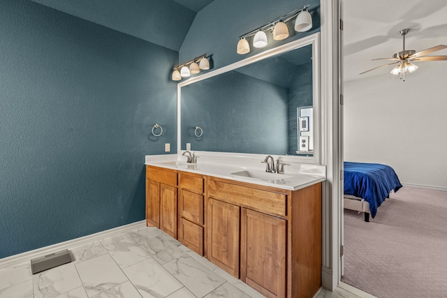 ensuite bathroom with lofted ceiling, visible vents, marble finish floor, and a sink