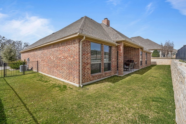 view of side of property featuring a patio area, a lawn, brick siding, and a fenced backyard