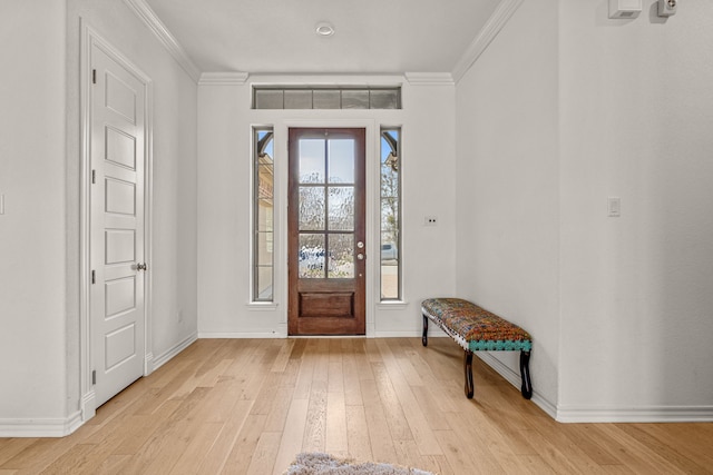 entrance foyer with baseboards, crown molding, and light wood finished floors