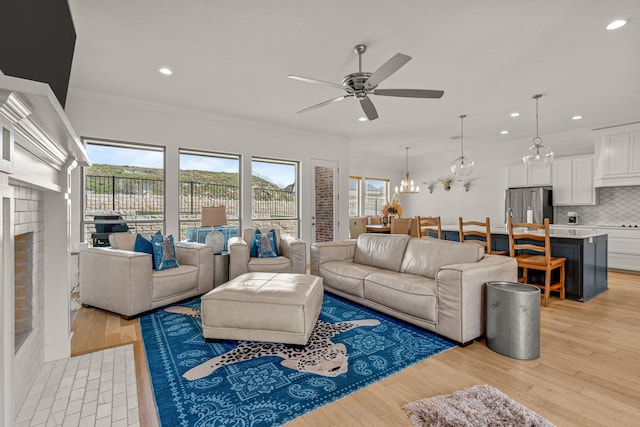 living room with crown molding, recessed lighting, and light wood-type flooring