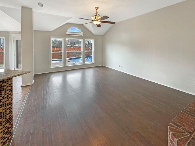 unfurnished living room featuring a ceiling fan, visible vents, baseboards, lofted ceiling, and dark wood-style flooring