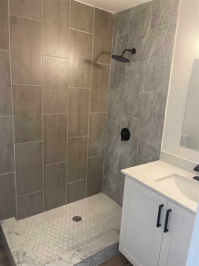 bathroom with vanity and a tile shower