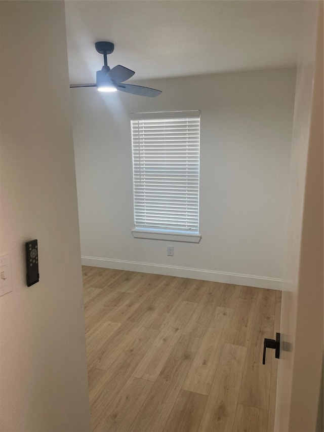 spare room featuring ceiling fan, baseboards, and light wood-style flooring