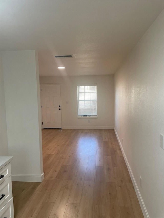 unfurnished room with visible vents, baseboards, and light wood finished floors