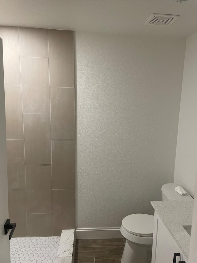 full bath featuring visible vents, toilet, wood finished floors, baseboards, and vanity