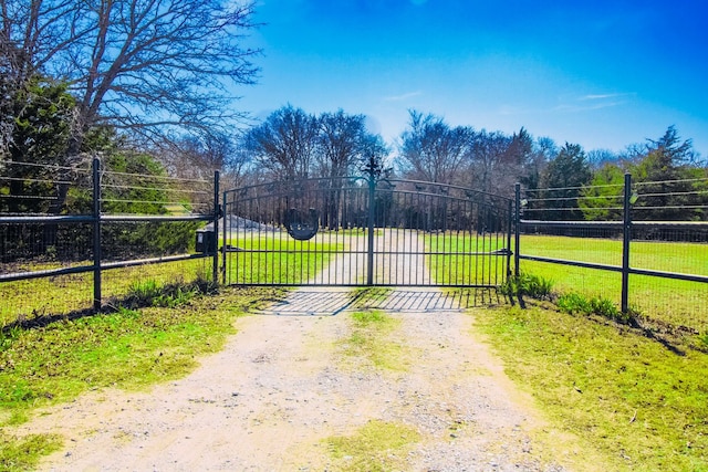 view of gate featuring a lawn and fence