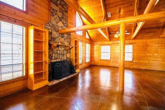 unfurnished living room featuring wood walls, wooden ceiling, and a healthy amount of sunlight