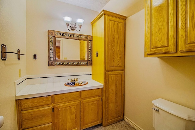 bathroom featuring toilet, vanity, and baseboards