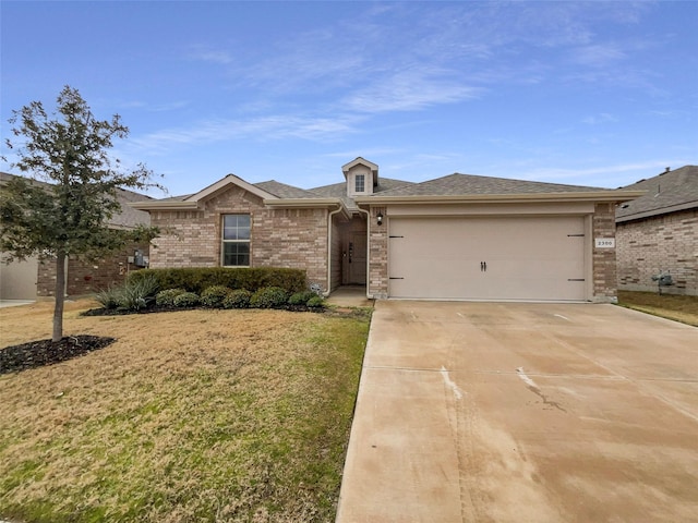 view of front of property featuring brick siding, a front lawn, roof with shingles, driveway, and an attached garage