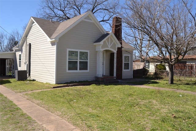 view of front of property featuring a front yard, fence, central AC, and a chimney