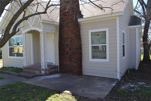 view of property exterior with a shingled roof