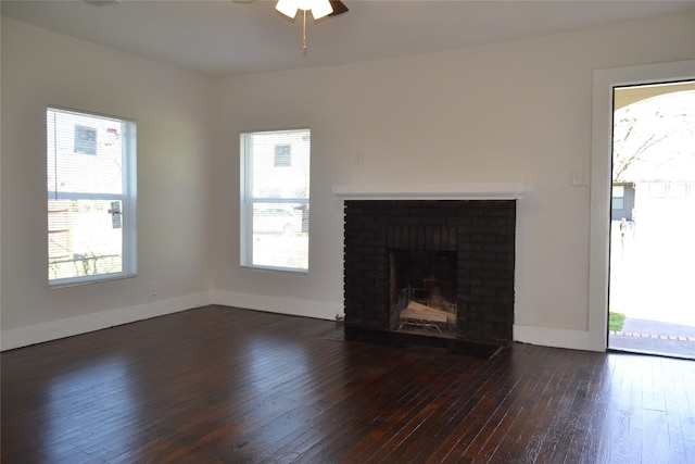 unfurnished living room with a ceiling fan, baseboards, dark wood-type flooring, and a fireplace