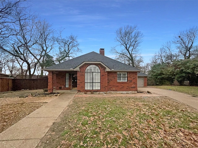 view of front facade featuring brick siding, a shingled roof, a chimney, and fence