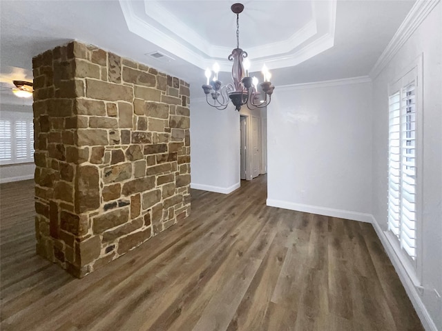 unfurnished dining area with visible vents, a notable chandelier, wood finished floors, crown molding, and a raised ceiling