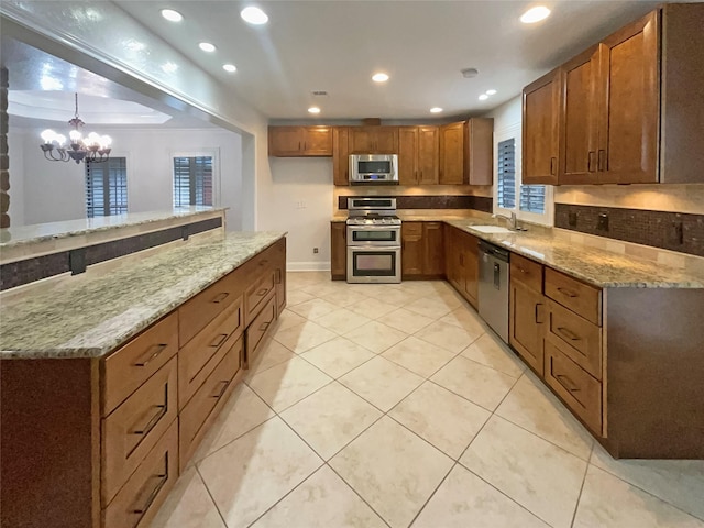 kitchen featuring light stone countertops, recessed lighting, a sink, stainless steel appliances, and brown cabinets