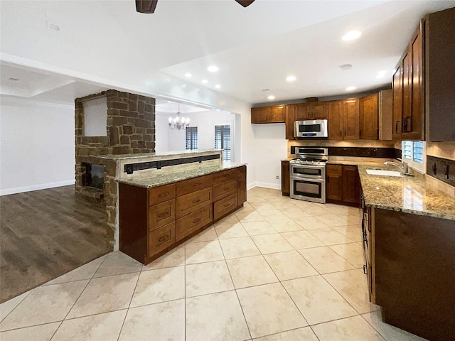 kitchen featuring a sink, light tile patterned flooring, light stone countertops, and stainless steel appliances