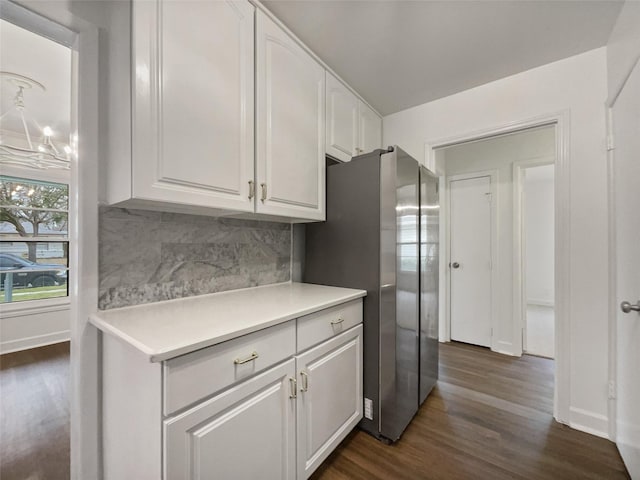 kitchen with dark wood finished floors, white cabinets, backsplash, and freestanding refrigerator