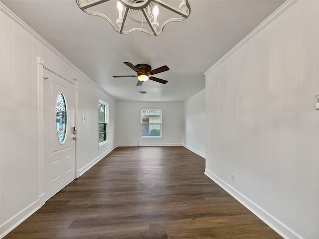 foyer featuring baseboards, dark wood finished floors, crown molding, and ceiling fan with notable chandelier