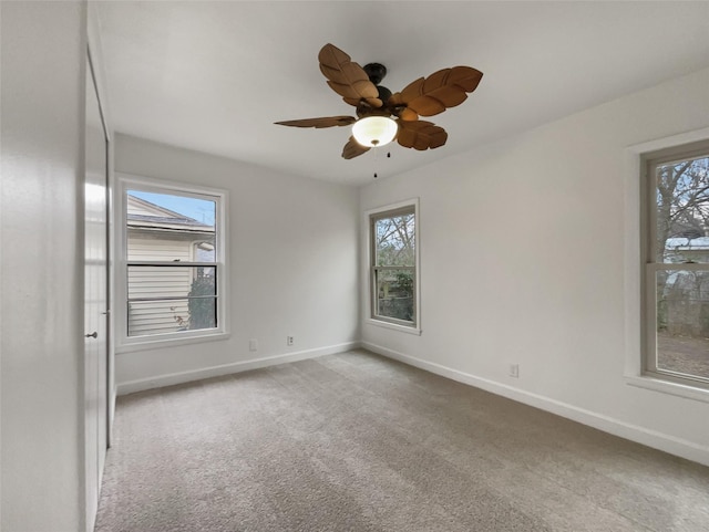 carpeted empty room with baseboards and a ceiling fan