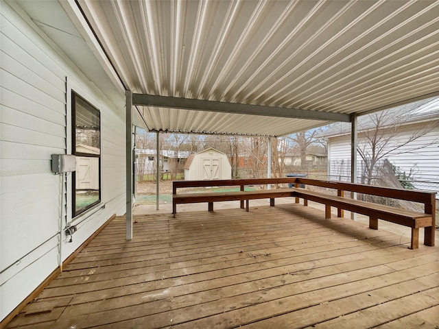 wooden terrace with a storage unit and an outdoor structure