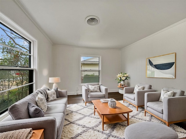 living area with visible vents, plenty of natural light, and wood finished floors