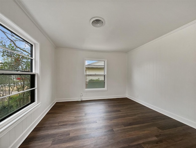 empty room featuring dark wood-type flooring, crown molding, visible vents, and baseboards