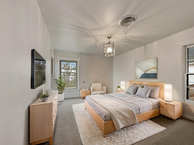 bedroom with a notable chandelier, visible vents, and carpet