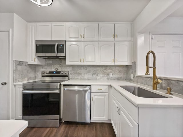 kitchen featuring a sink, stainless steel appliances, backsplash, and white cabinets