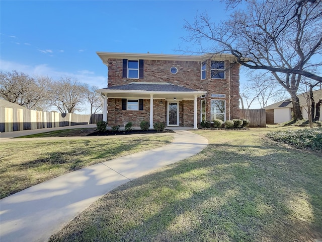 traditional-style house with brick siding, a front lawn, and fence