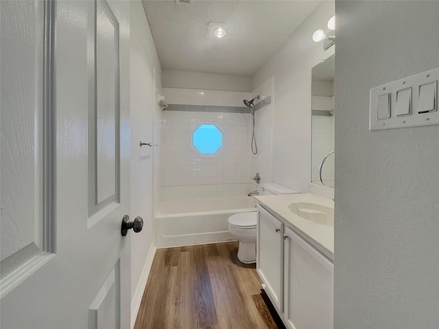 full bath with toilet,  shower combination, wood finished floors, and vanity