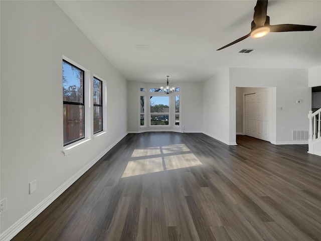 unfurnished living room featuring ceiling fan with notable chandelier, baseboards, visible vents, and dark wood-style flooring