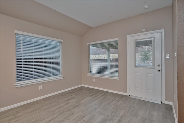 interior space featuring baseboards, lofted ceiling, and wood finished floors