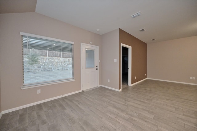 empty room with visible vents, baseboards, and wood finished floors