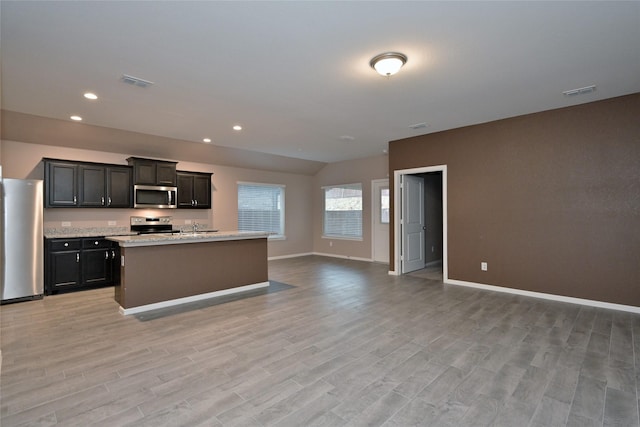 kitchen with light wood-style flooring, visible vents, open floor plan, and stainless steel appliances