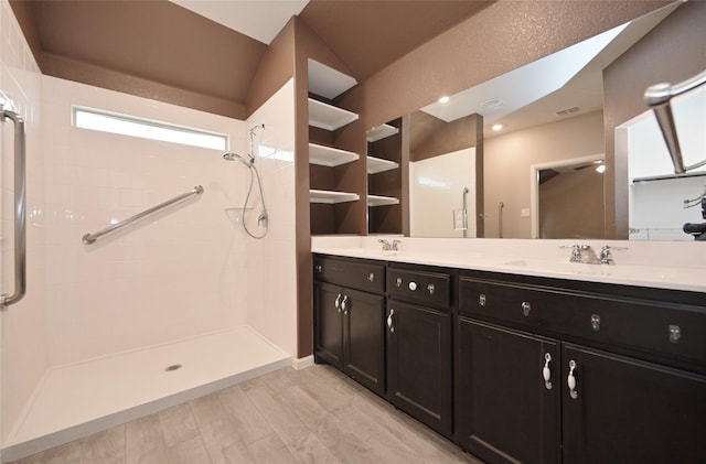 full bathroom featuring a sink, double vanity, and a shower stall