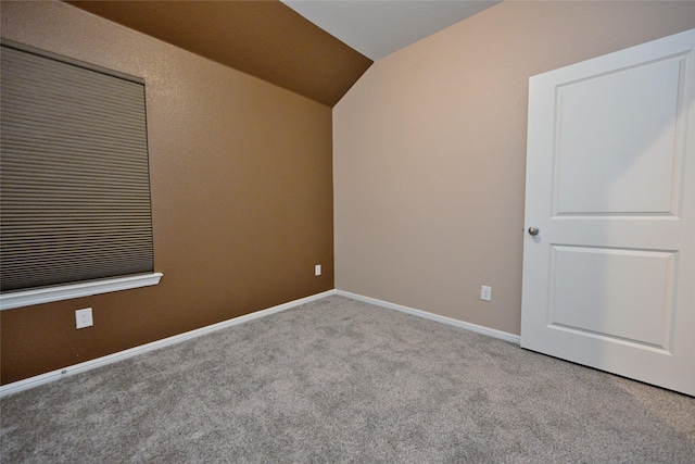 spare room with lofted ceiling, carpet, and baseboards