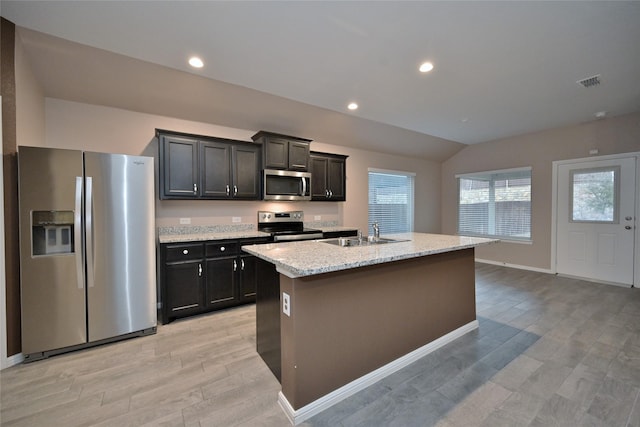 kitchen with light wood-style flooring, a sink, recessed lighting, stainless steel appliances, and vaulted ceiling