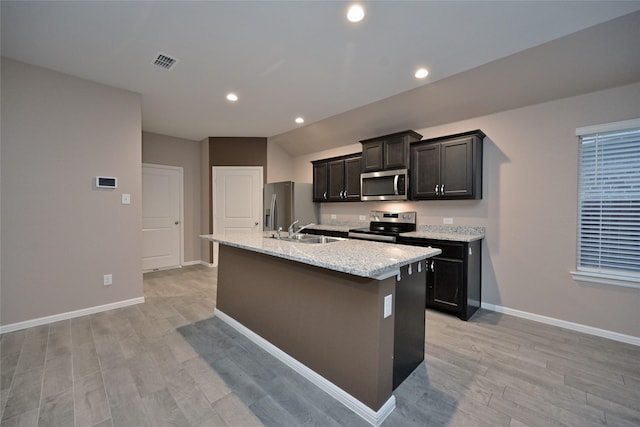 kitchen with light wood finished floors, visible vents, a center island with sink, stainless steel appliances, and a sink