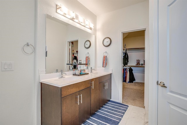 bathroom with a sink, double vanity, and a spacious closet