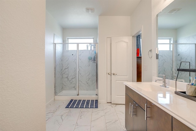 full bath featuring plenty of natural light, marble finish floor, and a marble finish shower